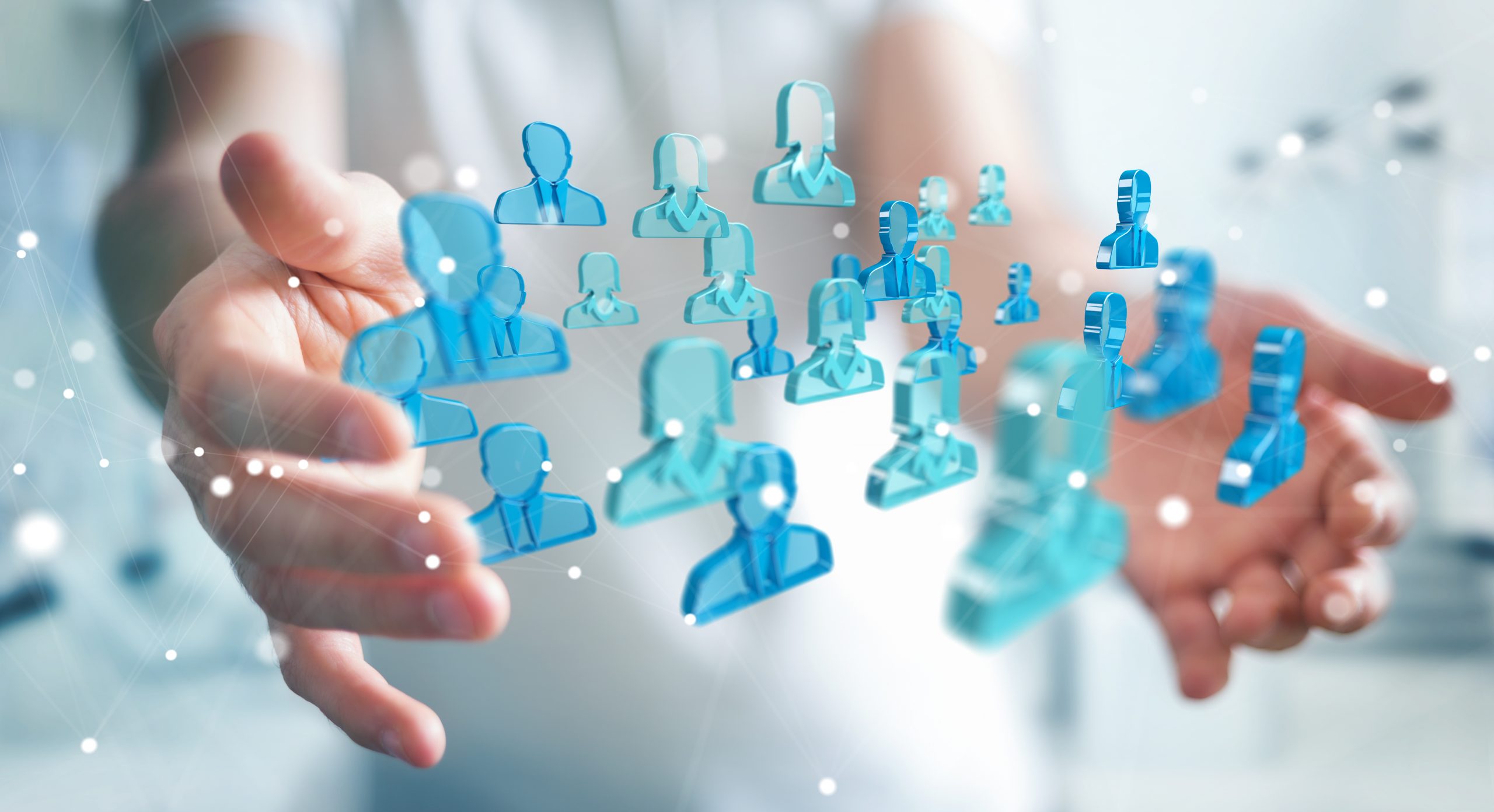 Businessman holding 3D rendering group of blue people Businessman on blurred background holding 3D rendering group of blue people