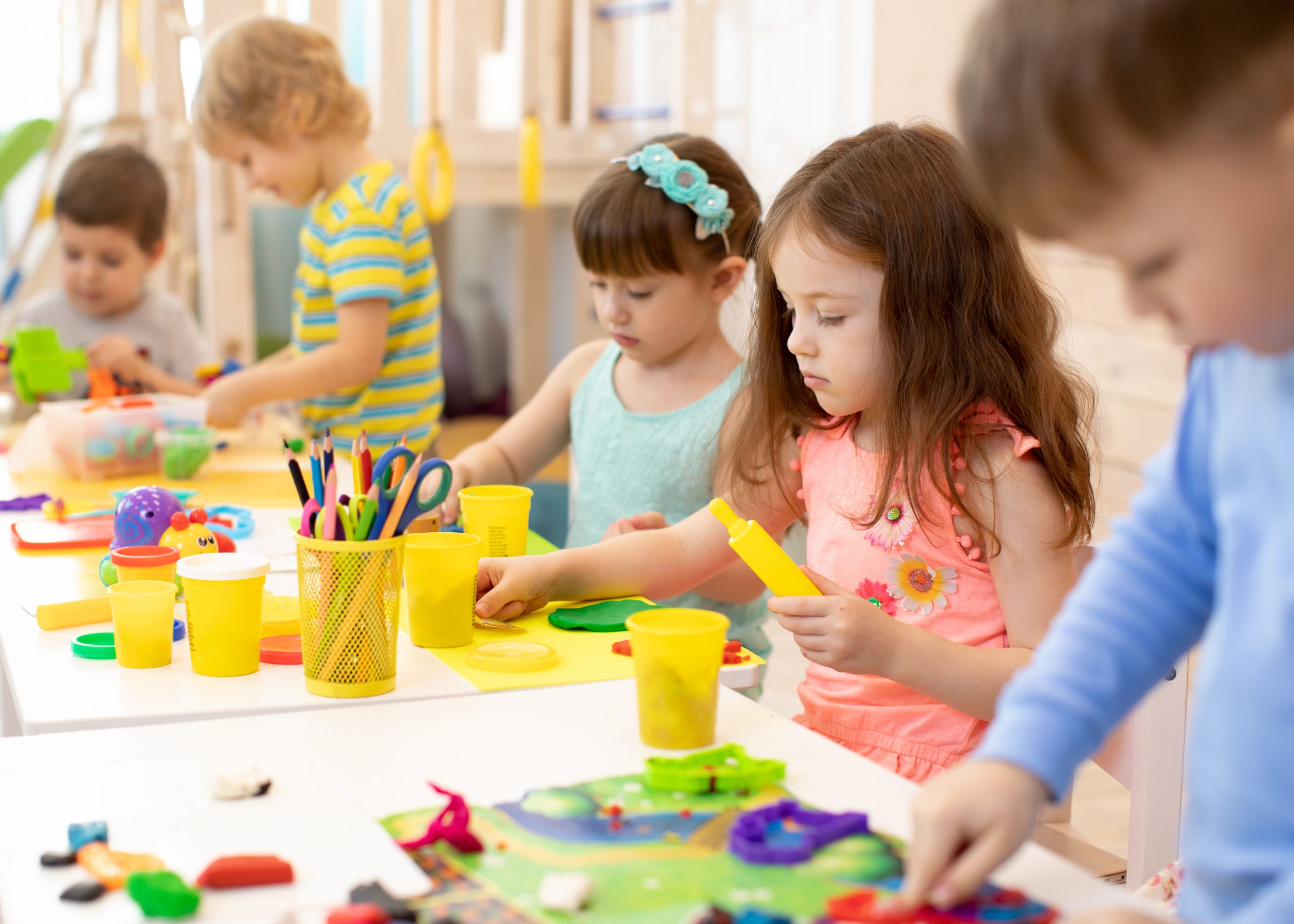 Art and craft activity in kindergarten. Preschool kids hands working in day care center. Group of children engaged in handcrafts